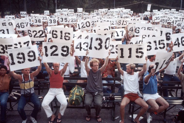 Image: People hold up signs representing the numbers of AIDS victims in a demonstration in support of AIDS victims in Central Park in New York City on Aug. 8, 1983.