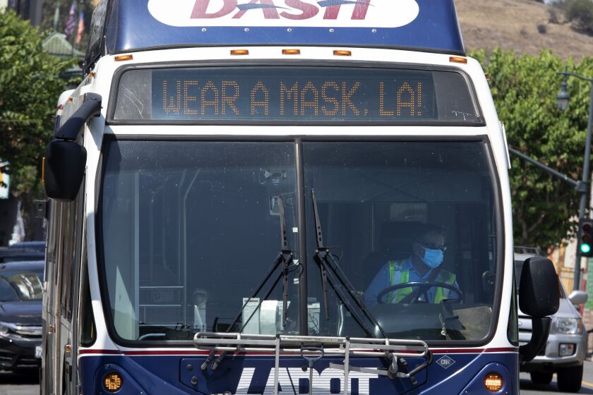 LOS ANGELES, CA - JULY 17: A bus in Chinatown encourages people to mask up. The LA County mask mandate will go into effect at 11:59 p.m. Saturday, July 17, 2021 requiring masks be worn indoors with the exception that masks can be removed if dining in a restaurant. Photographed in Chinatown on Saturday, July 17, 2021 in Los Angeles, CA. (Myung J. Chun / Los Angeles Times)